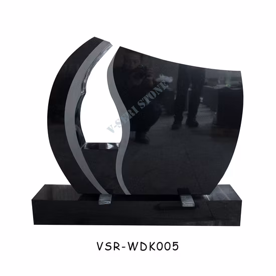 회색 손 조각품이 있는 하트 모양의 검은 대리석 묘비